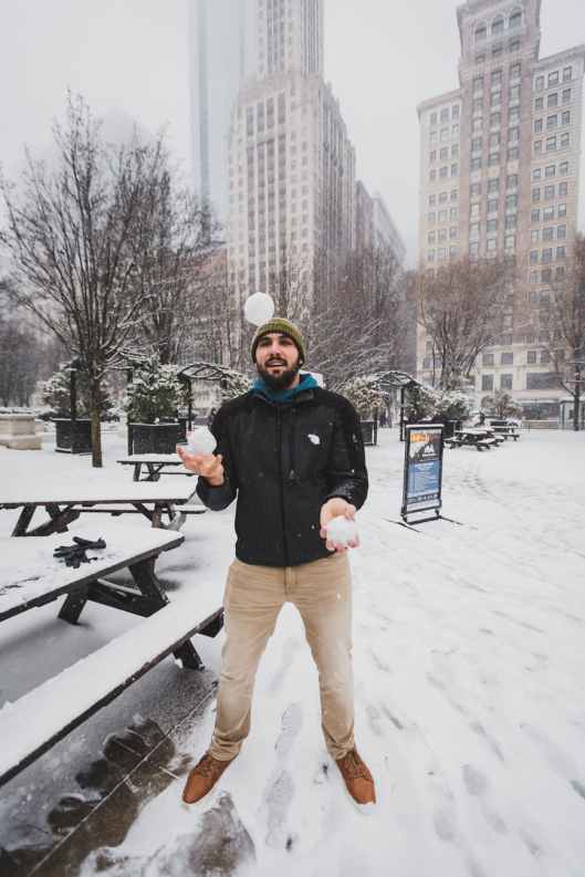 man playing with snowballs